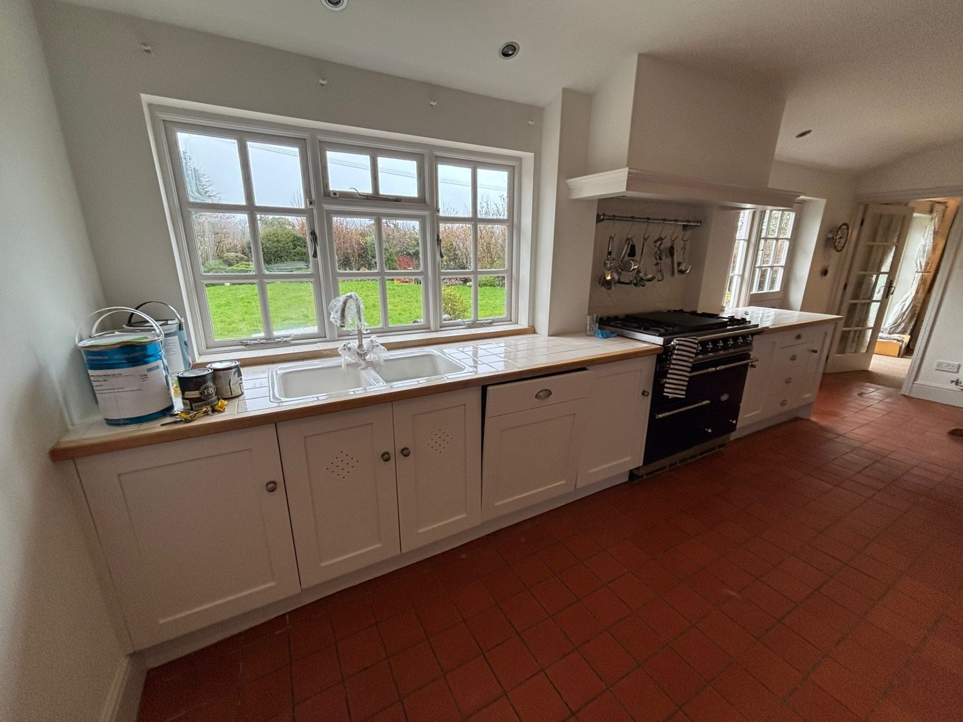 Country kitchen with bespoke hand painted white cabinets and range cooker in Surrey