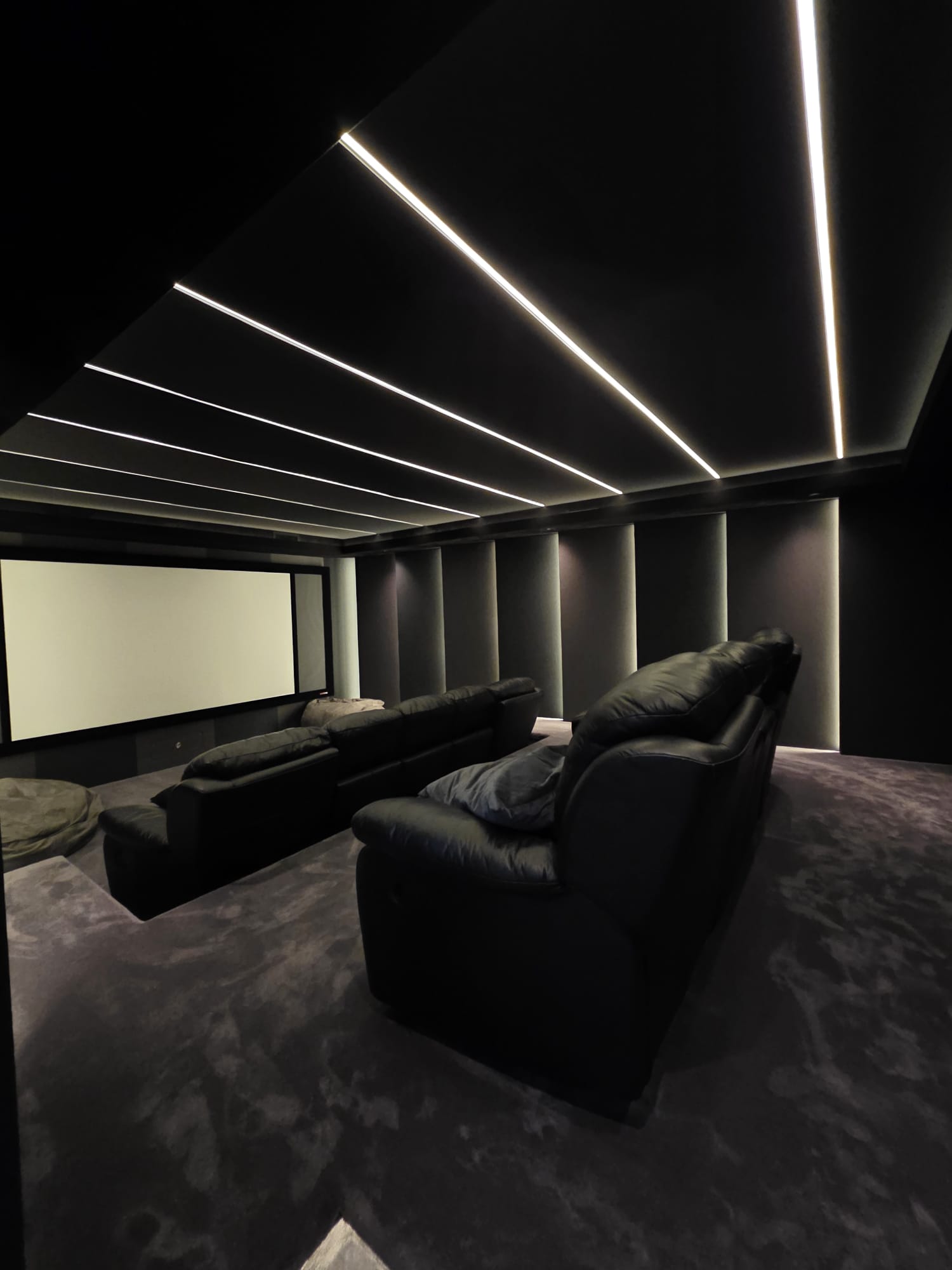 Home cinema room with dark feature wall painting and LED accent lighting