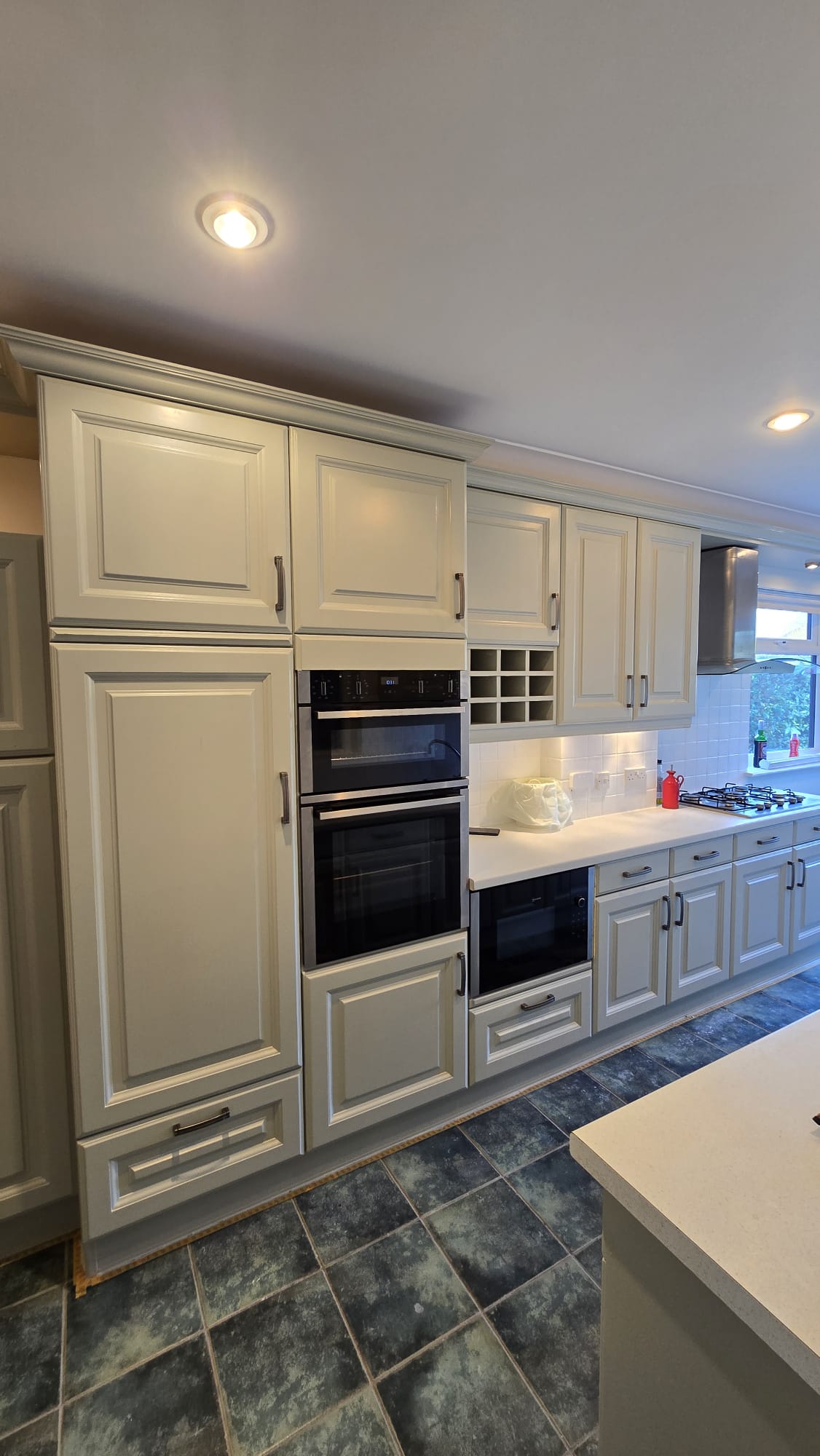 Cream HVLP spray painted kitchen cabinets with factory-smooth finish in Wimbledon home