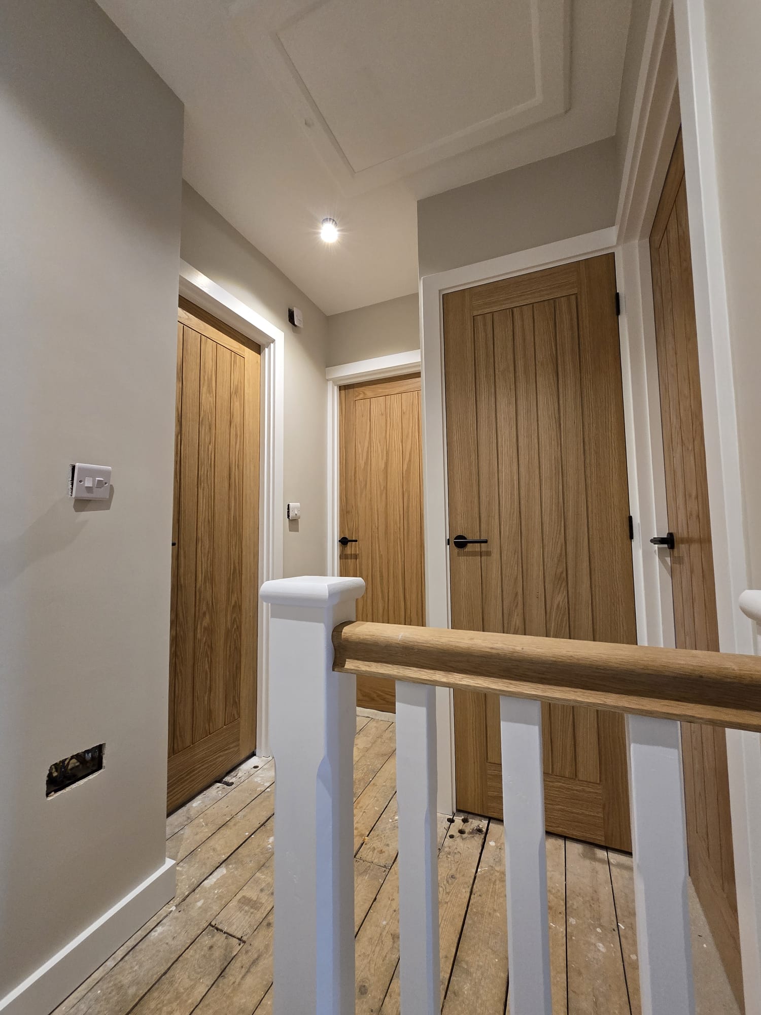 Restored oak doors and freshly painted white banister by Shreeve and Sons woodwork restoration team