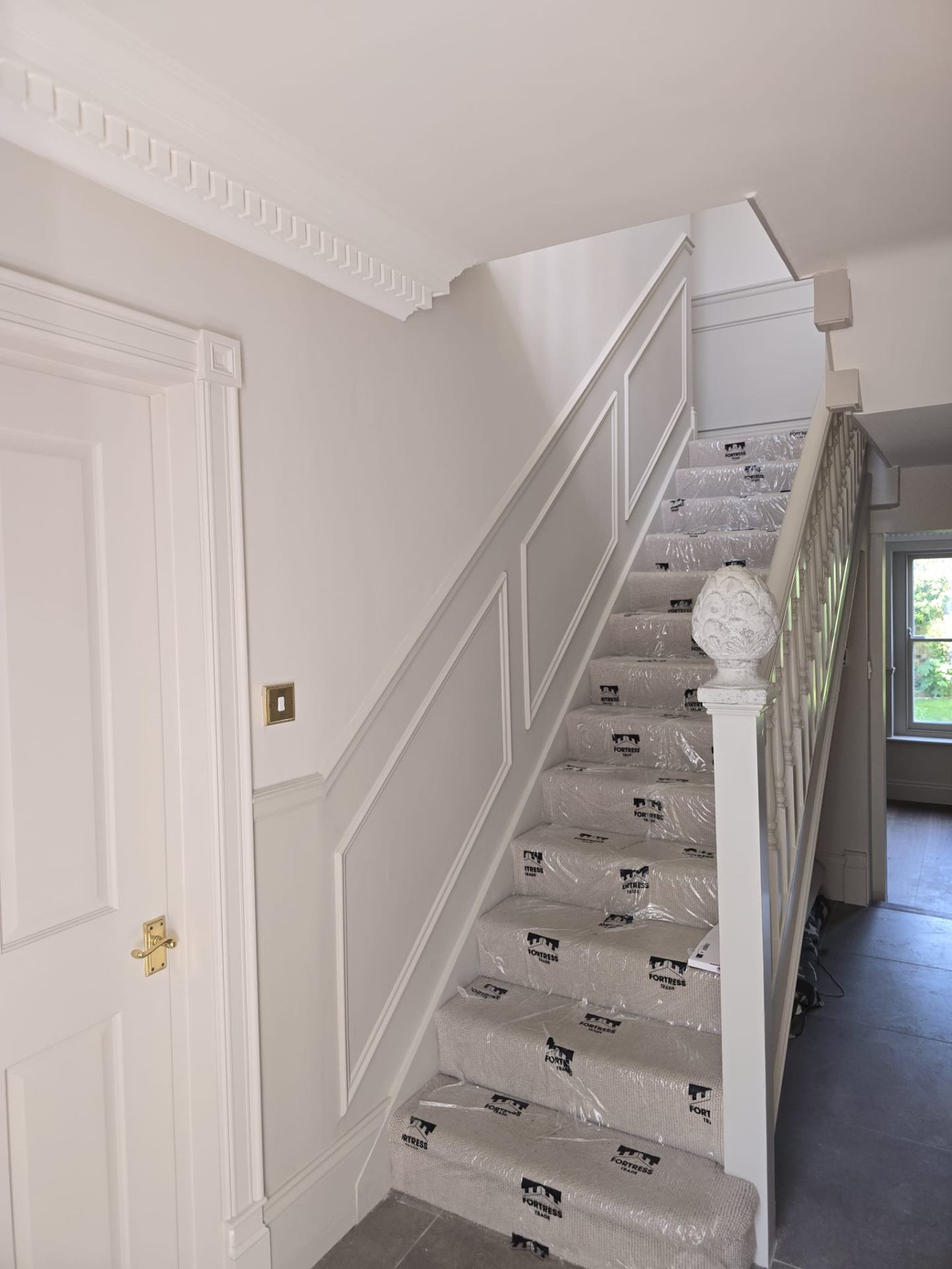 Restored white panelled staircase by professional decorators