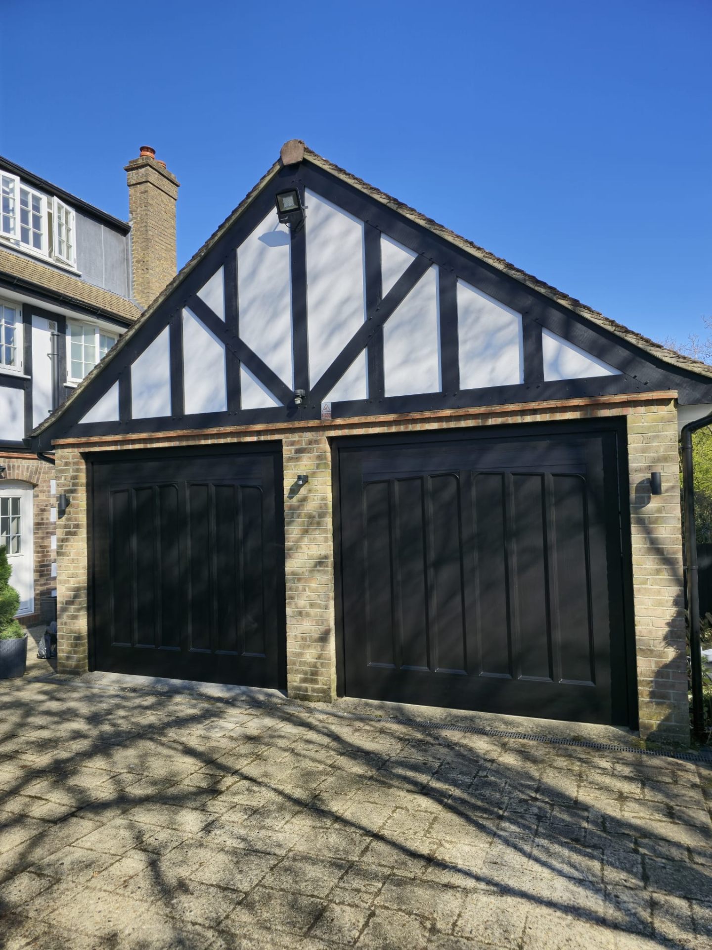 Painted garage doors and Tudor gable with weatherproof masonry coating