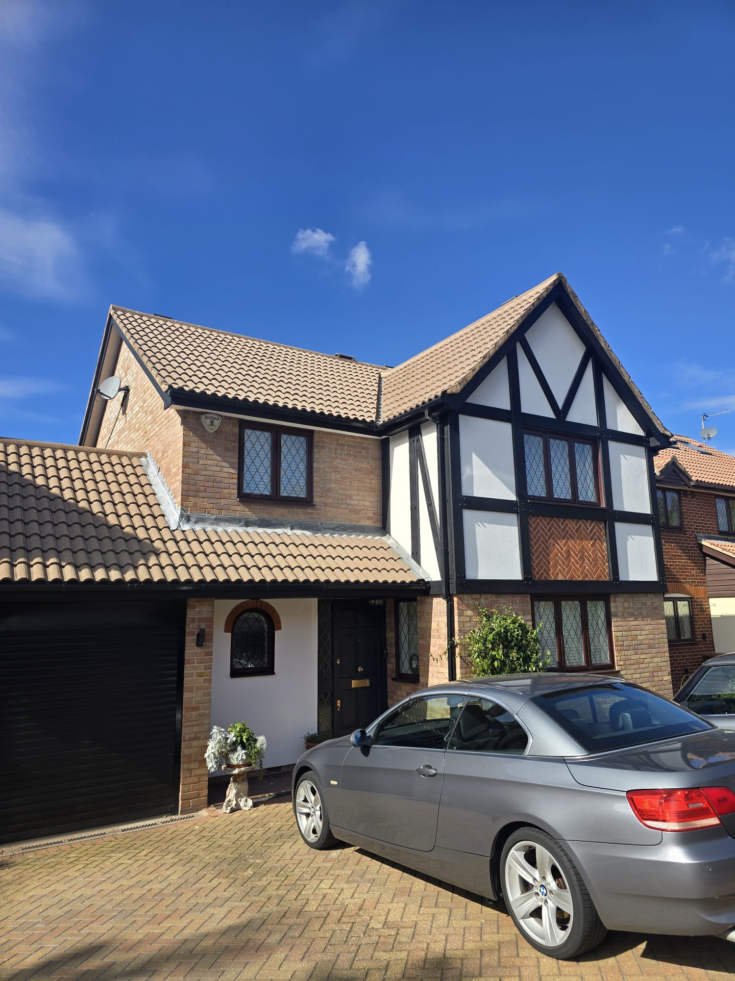 Exterior masonry painting on a Tudor property showing clean render finish