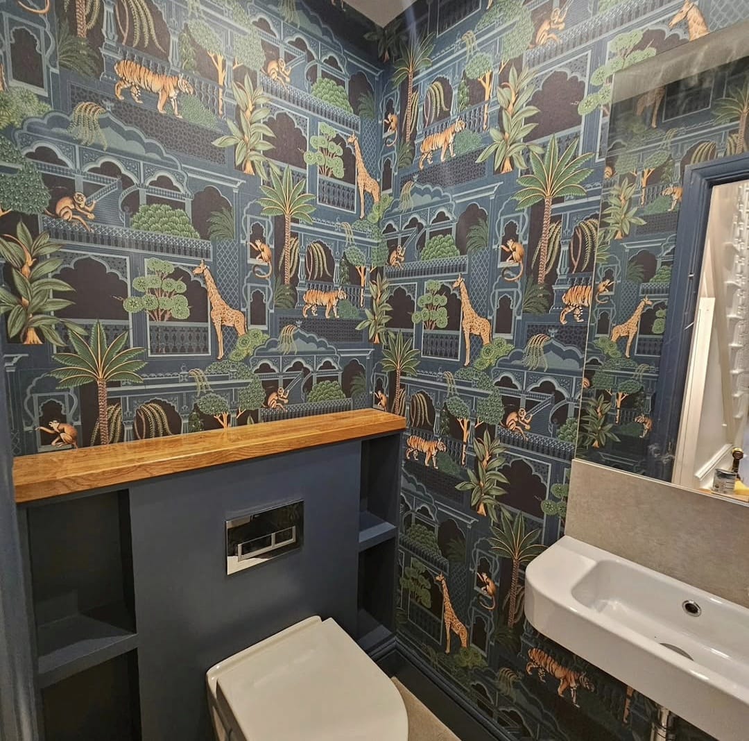 Downstairs WC with jungle pattern wallpaper, navy vanity unit and oak worktop