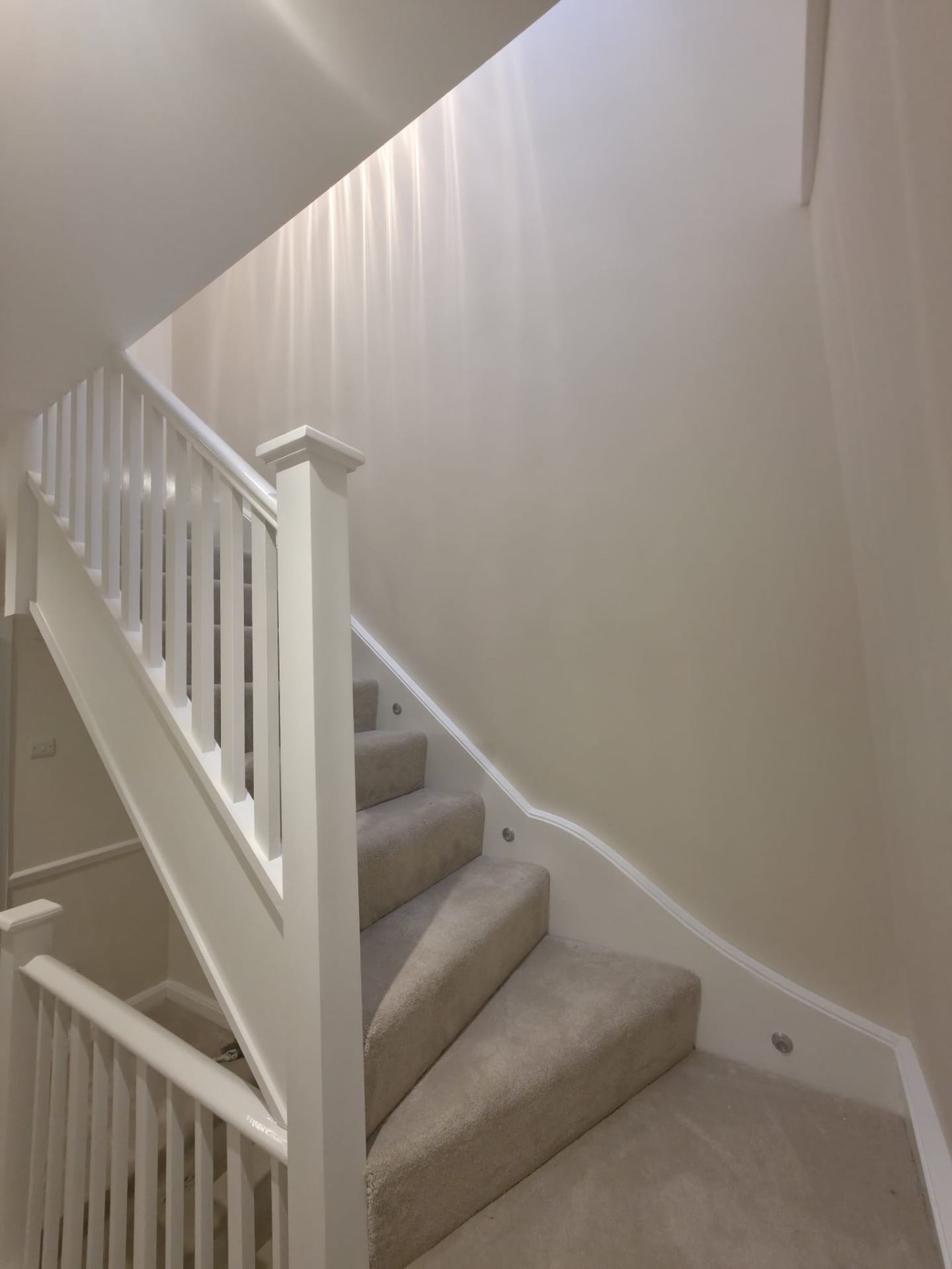 White painted staircase with carpeted treads in a modern home